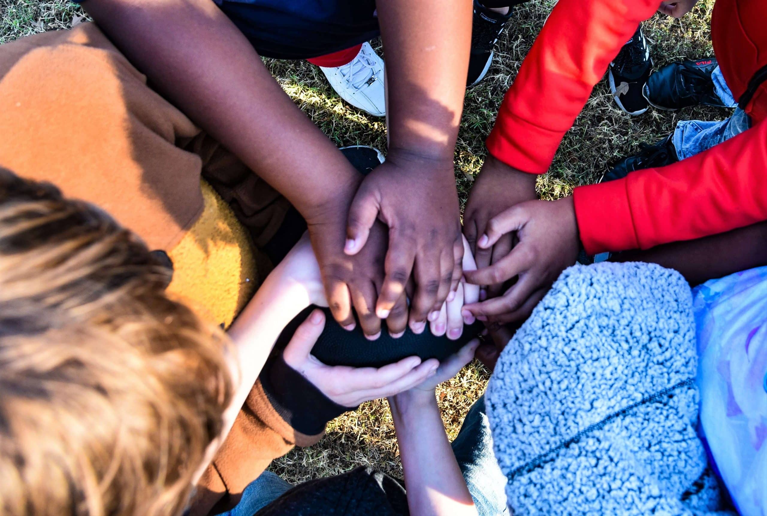 Foster care kids touch hands.