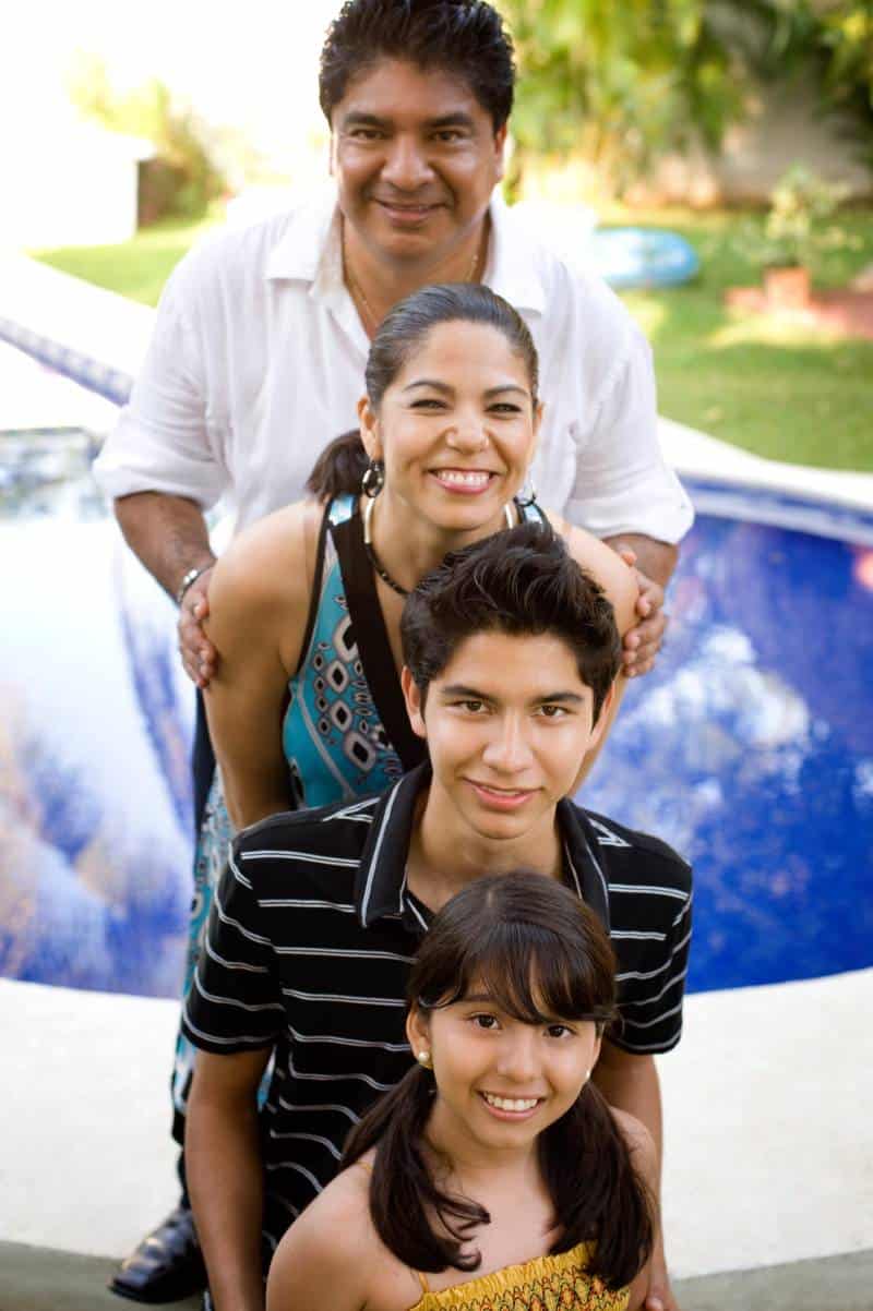 A husband and wife with their two foster children outside their Virginia home.